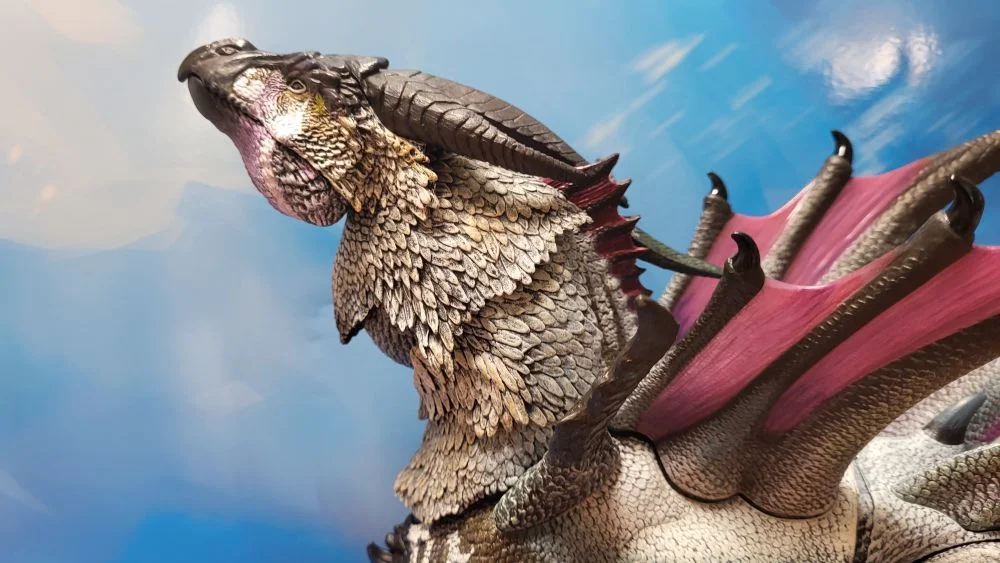A close up of the figure's head and neck from the left side view. Figure is in front of the included package backdrop. Jaw is closed. Neck is positioned as high as possible.
