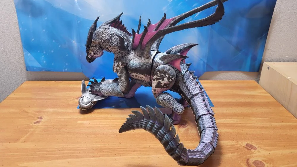 A left side view of the figure, slightly from above. Figure is in a pose similar to the original model kit, but perched upon the PNSO Dunkleosteus, to substitute for the narwhal in the original kit. Figure is in front of the included package backdrop.